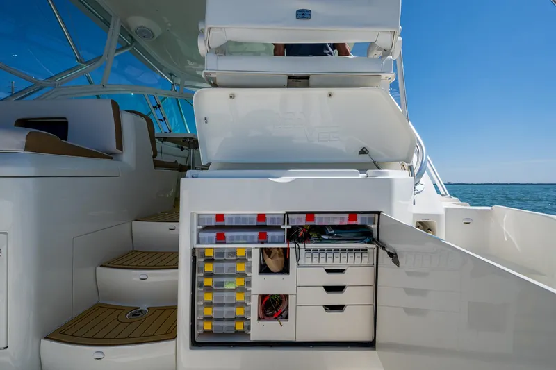 Refit 2018 - Reel Deal Yacht Photos Pics 2012 SeaVee 43 Express boat interior with open storage compartments and steps, under clear blue sky.