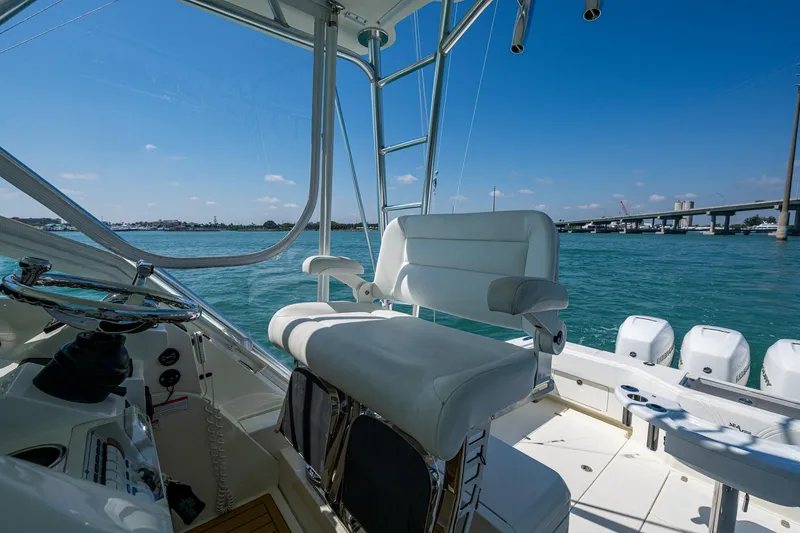 Refit 2018 - Reel Deal Yacht Photos Pics 2012 SeaVee 43 Express boat interior with helm seat, overlooking calm blue waters.