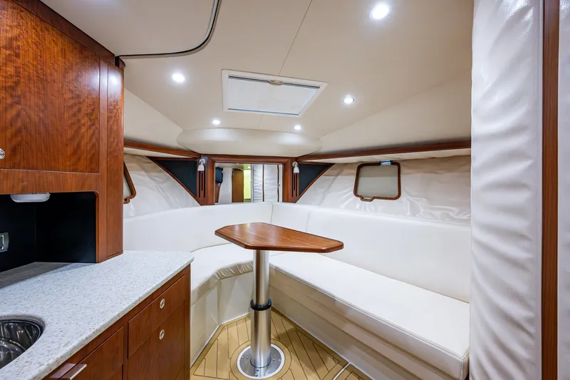 Refit 2018 - Reel Deal Yacht Photos Pics Luxurious interior of 2012 SeaVee 43 Express yacht with wood accents and cozy seating area.