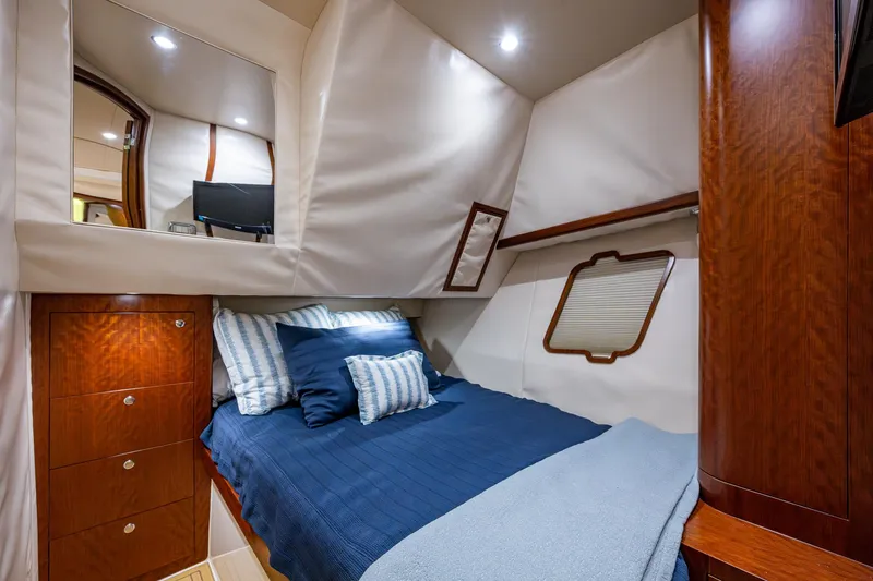 Refit 2018 - Reel Deal Yacht Photos Pics Luxurious cabin interior of 2012 SeaVee 43 Express with cozy bed and elegant wood finish.