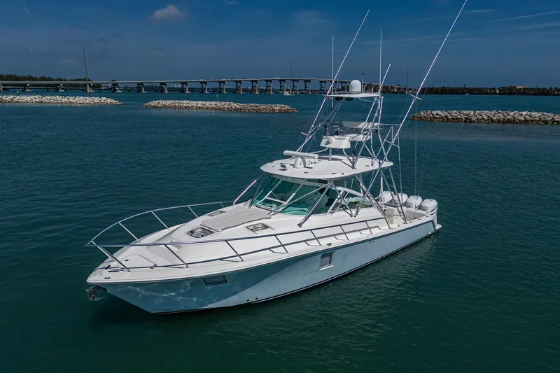 Refit 2018 - Reel Deal Yacht Photos Pics 2012 SeaVee 43 Express boat on calm water near a bridge.
