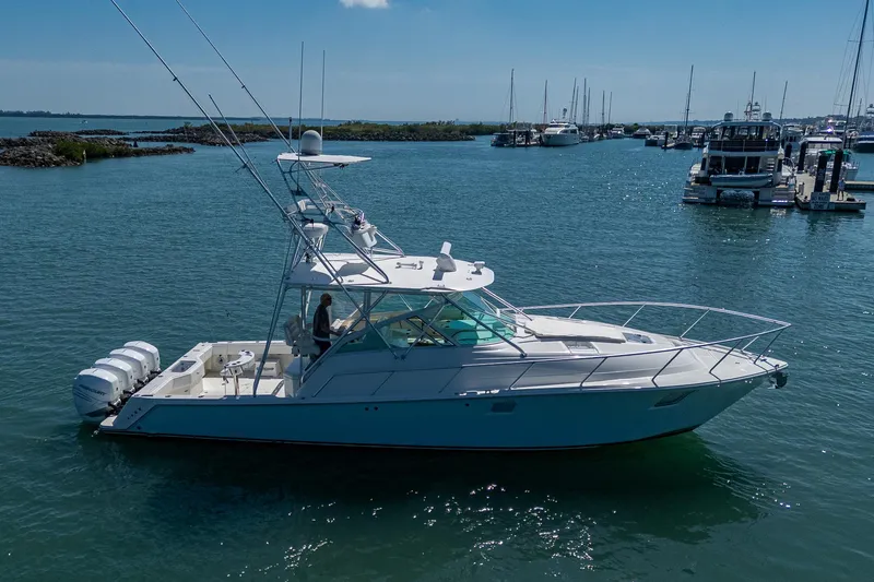 Refit 2018 - Reel Deal Yacht Photos Pics 2012 SeaVee 43 Express yacht on calm water, docked near a marina.