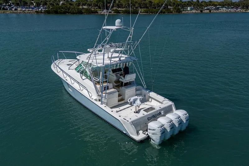 Refit 2018 - Reel Deal Yacht Photos Pics 2012 SeaVee 43 Express boat with triple outboard engines on calm water.