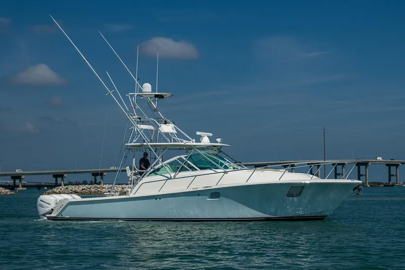 Refit 2018 - Reel Deal Yacht Photos Pics 2012 SeaVee 43 Express boat on water, clear sky, bridge in background.