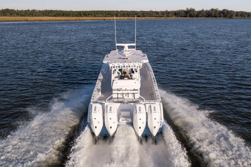  Yacht Photos Pics 2024 Invincible 40 Catamaran cruising on open water, rear view with powerful engines.