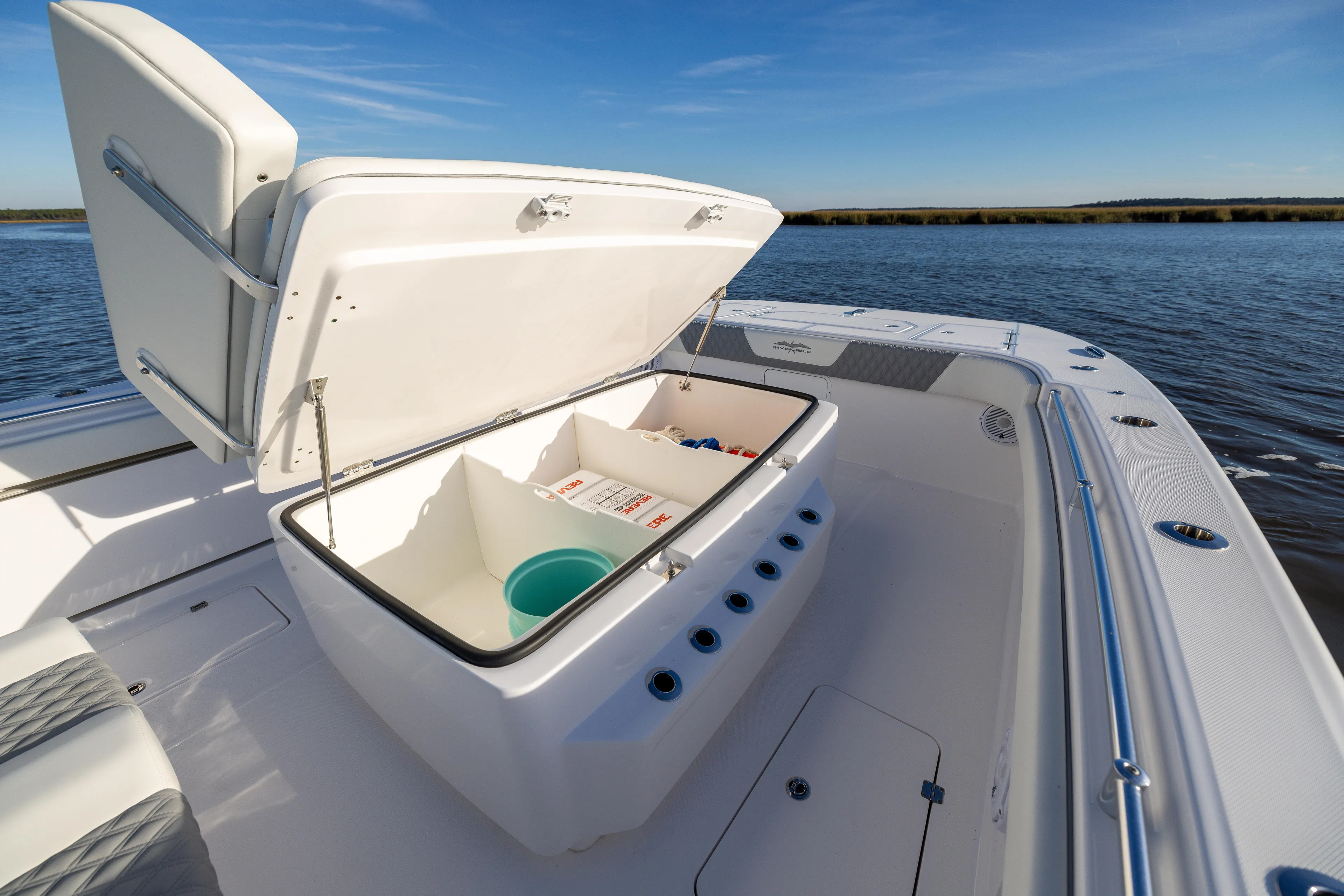  Yacht Photos Pics 2024 Invincible 40 Catamaran with open storage compartment on deck, near water.