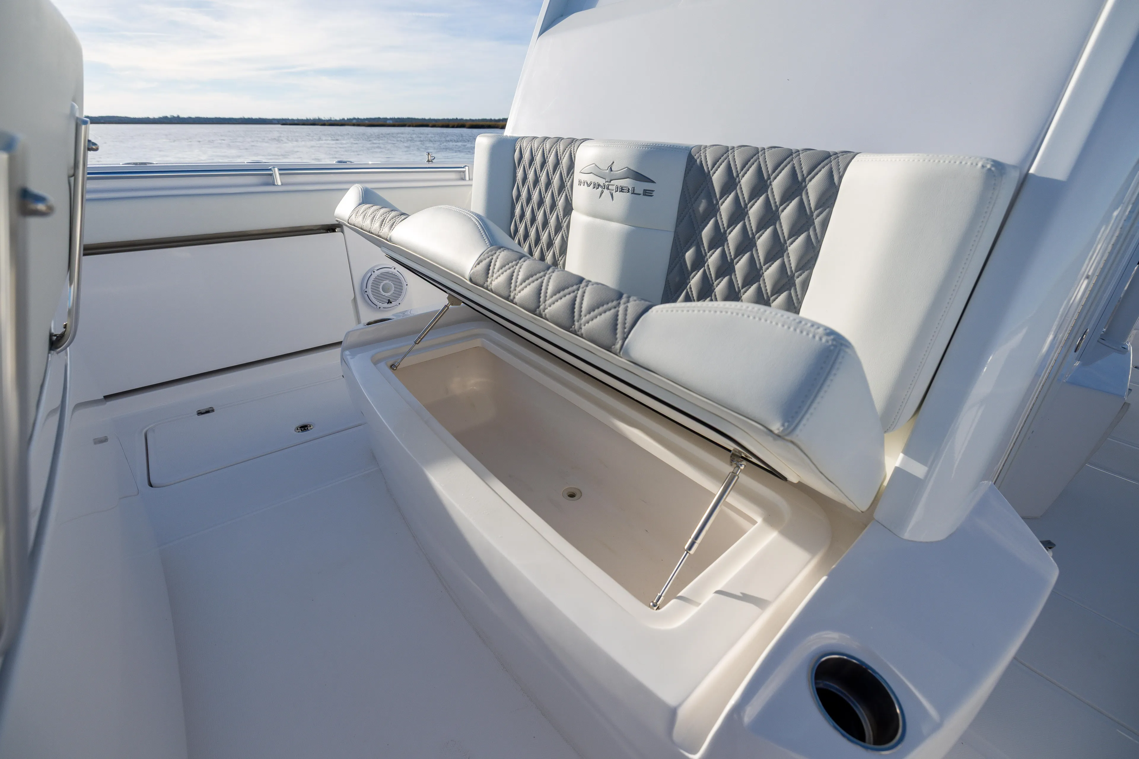  Yacht Photos Pics 2024 Invincible 40 Catamaran seat with storage compartment, featuring quilted upholstery.