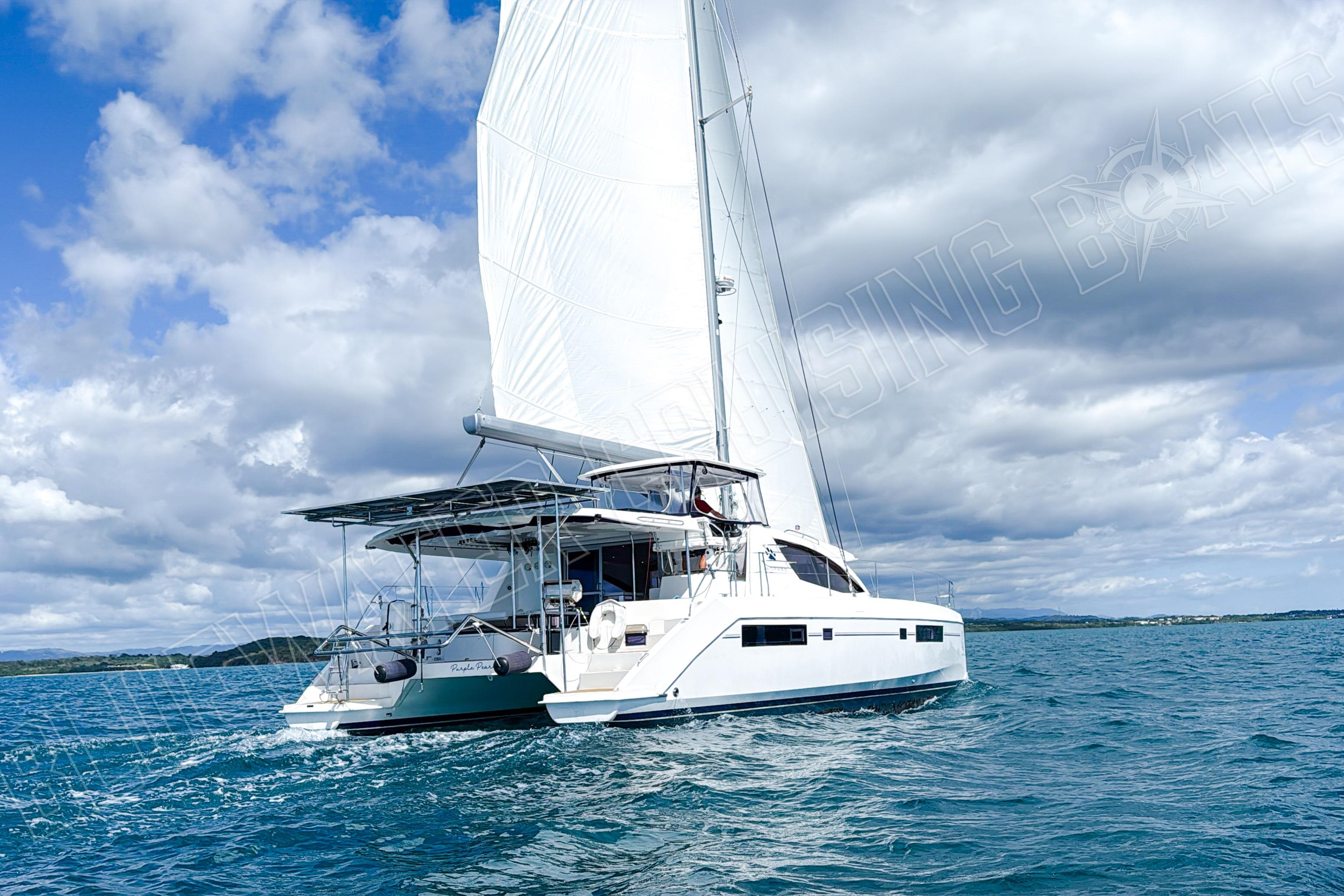 Sailing catamaran Leopard 48, 2015 model, cruising on open water under a cloudy sky.