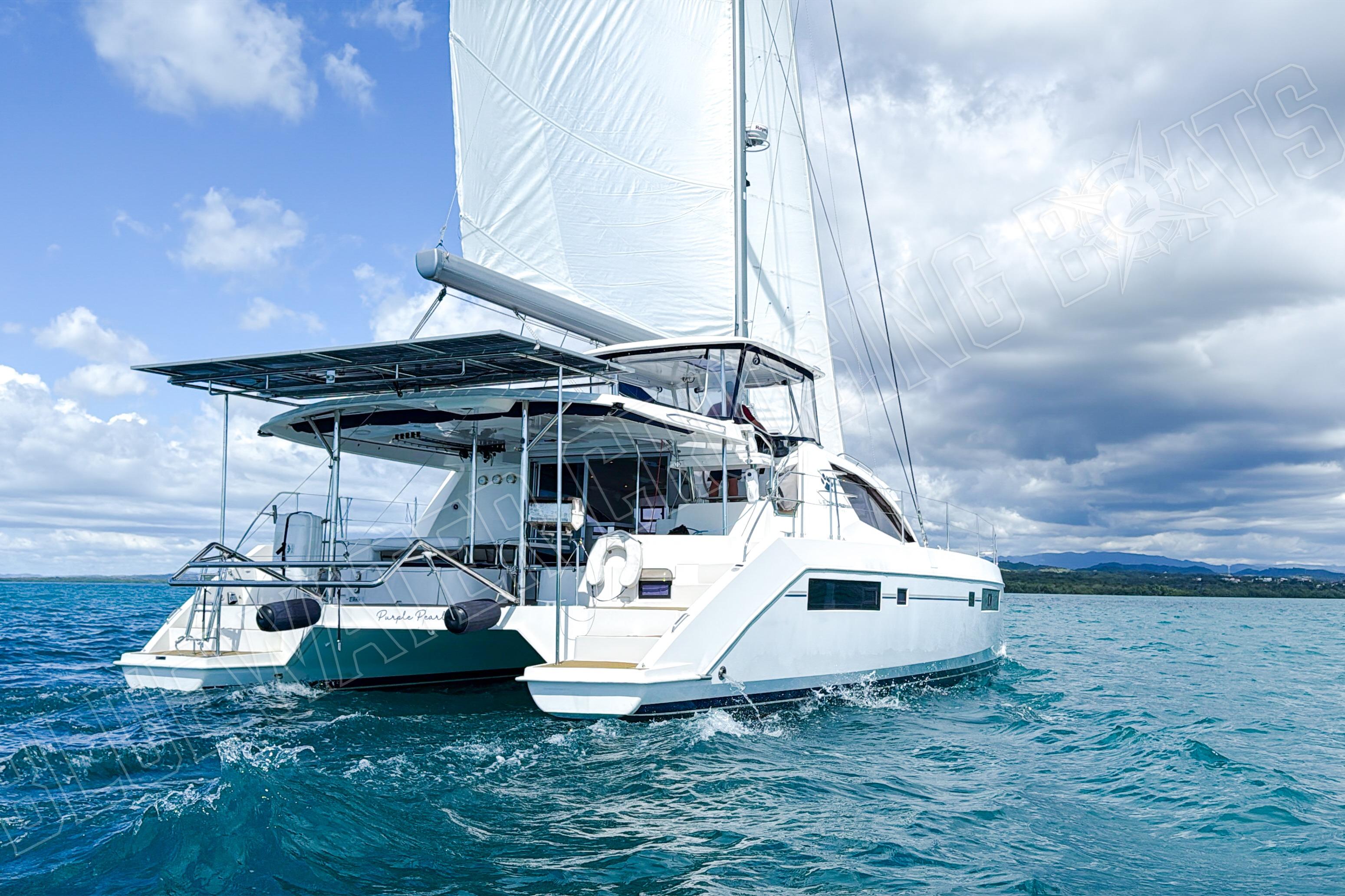2015 Leopard 48 catamaran sailing on blue ocean under cloudy sky.