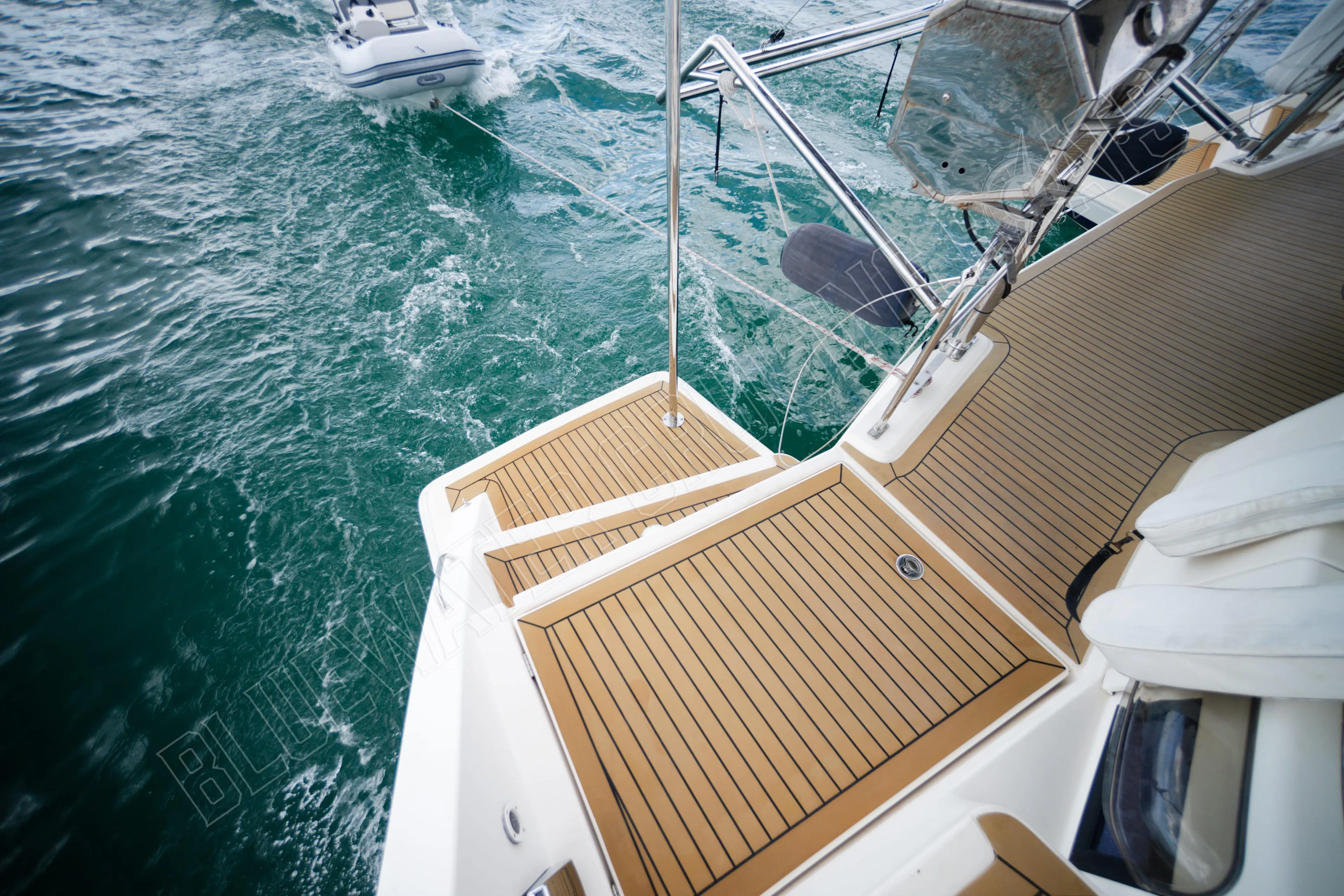 Deck view of 2015 Leopard 48 yacht with tender in turquoise waters.
