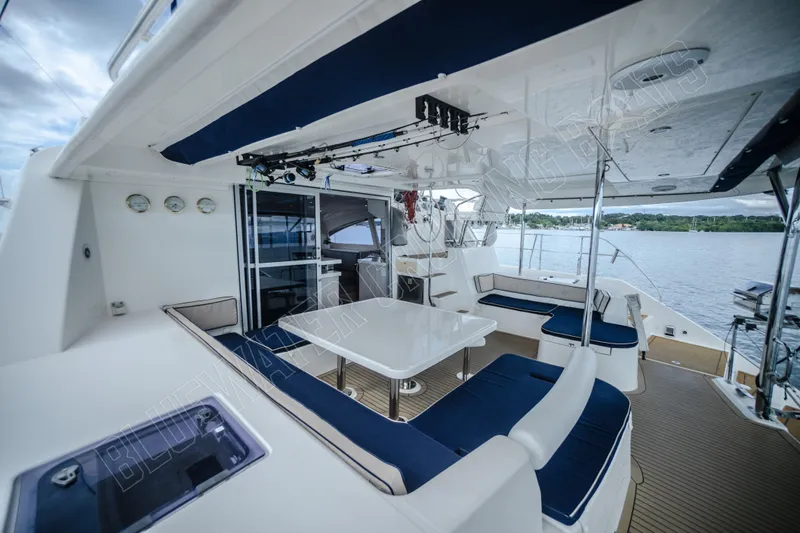Purple Pearl Yacht Photos Pics Luxurious 2015 Leopard 48 yacht deck with seating and dining area, overlooking serene waters.