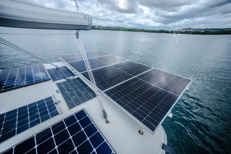 Purple Pearl Yacht Photos Pics Solar panels on a 2015 Leopard 48 yacht, sailing on a calm lake under cloudy skies.