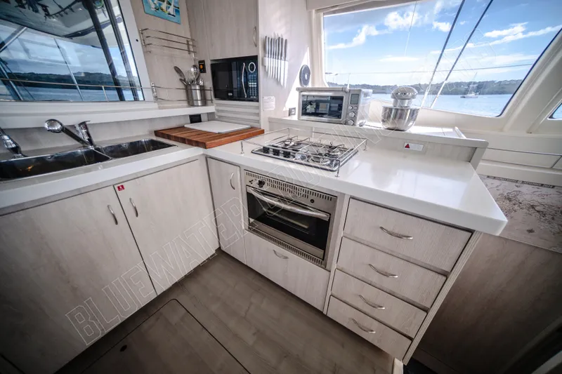 Purple Pearl Yacht Photos Pics Modern kitchen in a 2015 Leopard 48 yacht with stove, sink, and ocean view.
