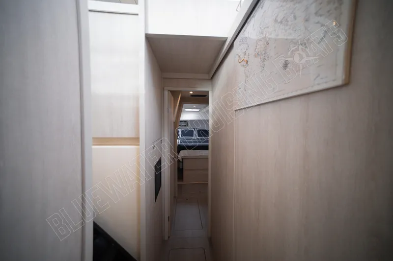Purple Pearl Yacht Photos Pics Narrow hallway inside 2015 Leopard 48 yacht, featuring light wood paneling and a wall map.