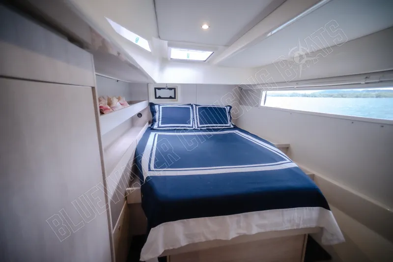 Purple Pearl Yacht Photos Pics Luxurious cabin interior of 2015 Leopard 48 yacht with blue bedding and scenic window view.