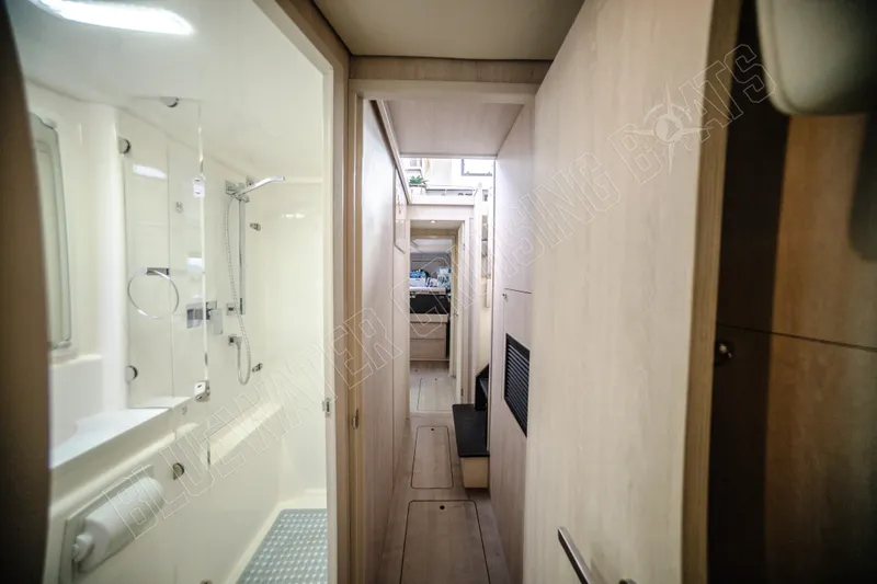 Purple Pearl Yacht Photos Pics Narrow hallway inside 2015 Leopard 48 yacht, featuring a modern bathroom and wooden interior.