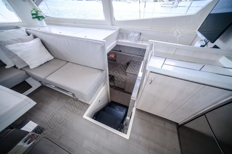 Purple Pearl Yacht Photos Pics Interior of 2015 Leopard 48 yacht, featuring modern seating and staircase with ocean view.