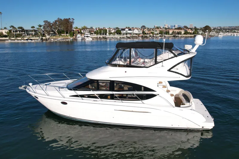 Cynisca Yacht Photos Pics 2006 Meridian 391 Sedan yacht cruising on a serene waterfront with cityscape background.