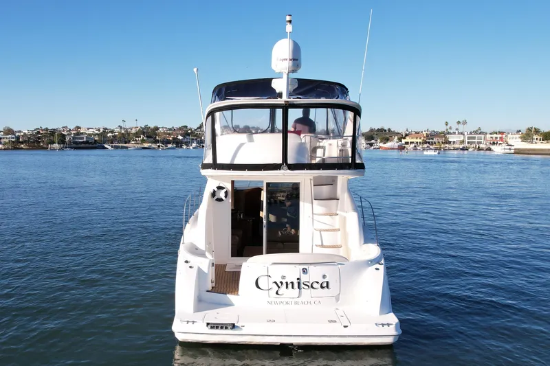 Cynisca Yacht Photos Pics 2006 Meridian 391 Sedan yacht on calm water, Newport Beach backdrop.