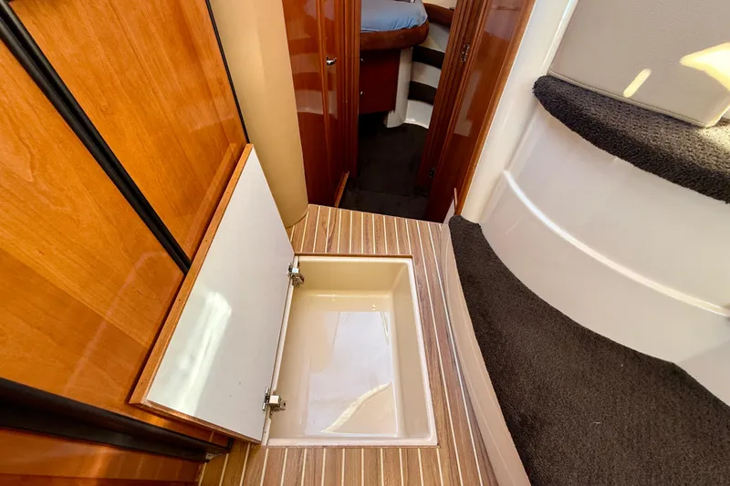 Cynisca Yacht Photos Pics 2006 Meridian 391 Sedan interior with open floor storage compartment and wooden finish.