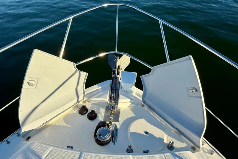 Cynisca Yacht Photos Pics Bow of 2006 Meridian 391 Sedan yacht with open anchor hatch, on calm water.