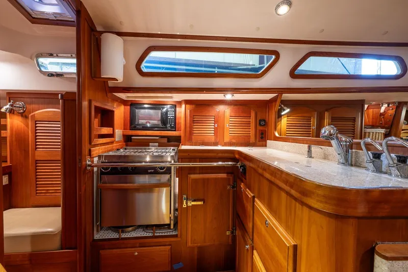 September Song Yacht Photos Pics Luxurious 2007 Sabre 386 yacht interior with wooden cabinetry and modern kitchen amenities.
