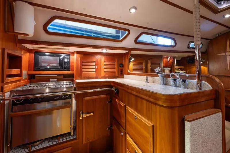 September Song Yacht Photos Pics Luxurious 2007 Sabre 386 yacht kitchen with wood cabinetry and modern appliances.