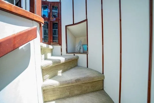 My Reality Yacht Photos Pics Interior staircase of 2012 Neptunus 62 Flybridge yacht with carpeted steps and wooden accents.