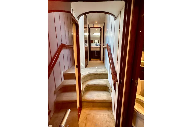 My Reality Yacht Photos Pics Interior of 2012 Neptunus 62 Flybridge yacht with carpeted stairs and wooden accents.