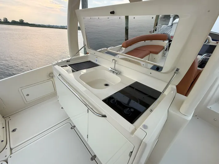Ufo Yacht Photos Pics 2018 Chris-Craft Launch 38 boat interior with kitchenette and sink, overlooking serene water.