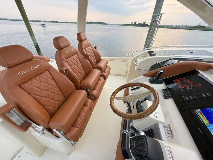 Ufo Yacht Photos Pics 2018 Chris-Craft Launch 38 interior with leather seats and modern dashboard, overlooking serene water.