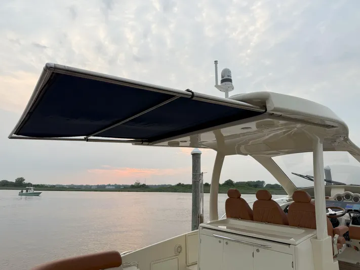 Ufo Yacht Photos Pics 2018 Chris-Craft Launch 38 boat with canopy, on calm water at sunset.