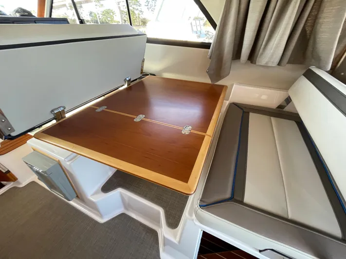  Yacht Photos Pics 2019 Cutwater C-302 Coupe interior with convertible dining table and cushioned seating.
