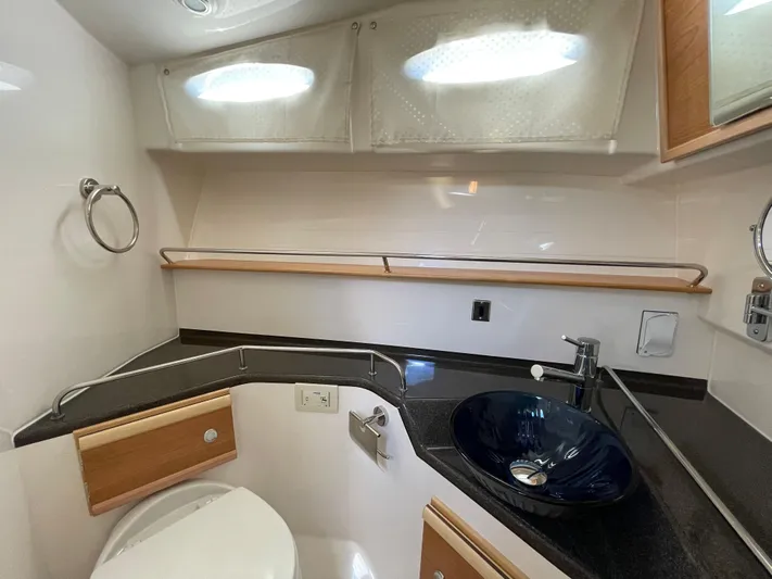 Yacht Photos Pics 2019 Cutwater C-302 Coupe bathroom with modern sink, toilet, and storage shelves.