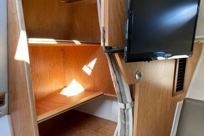  Yacht Photos Pics 2019 Cutwater C-302 Coupe interior with wooden cabinetry and mounted TV.
