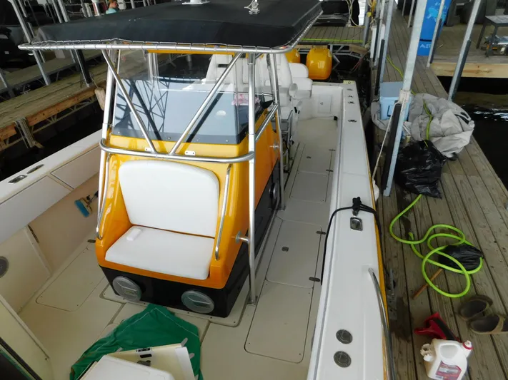 Fountain Repowered Yacht Photos Pics 2004 Fountain 38 Sportfish CC boat with orange console and white seating, docked with equipment nearby.