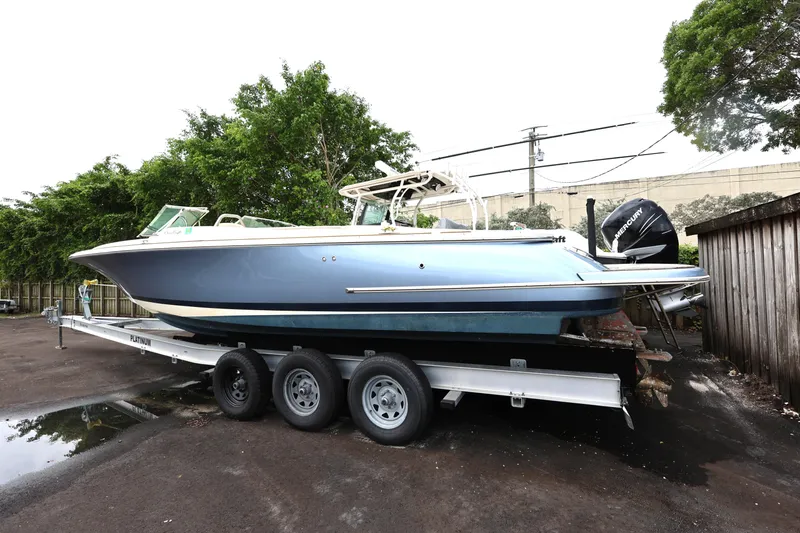  Yacht Photos Pics 2020 Chris-Craft 30 Launch boat on trailer, parked outdoors with trees in background.