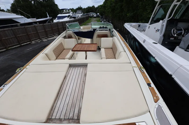  Yacht Photos Pics 2020 Chris-Craft 30 Launch boat with spacious seating and wooden deck, docked beside other vessels.