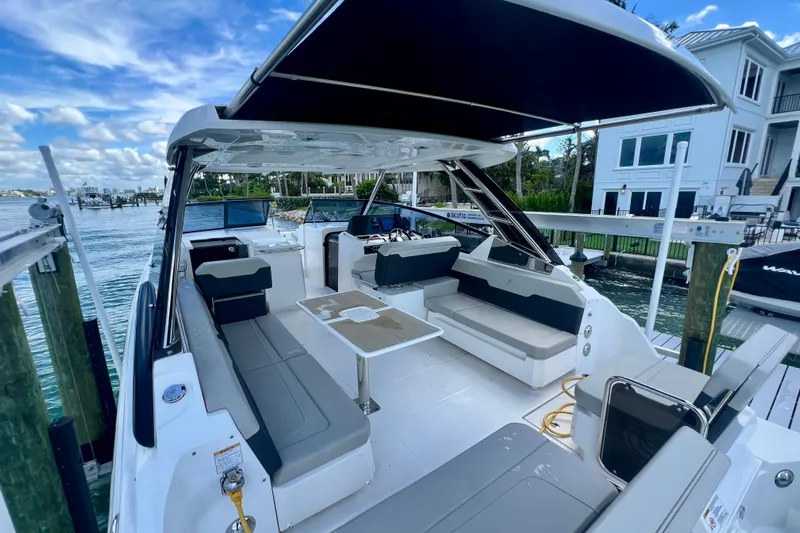  Yacht Photos Pics 2025 Aquila 32 Sport boat with spacious seating and modern design docked by waterfront.