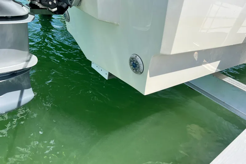  Yacht Photos Pics Aquila 32 Sport 2025 boat stern with outboard motor in green water.