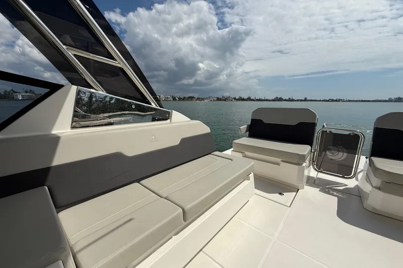  Yacht Photos Pics Aquila 32 Sport 2025 boat interior with seating, overlooking calm waters and cloudy sky.
