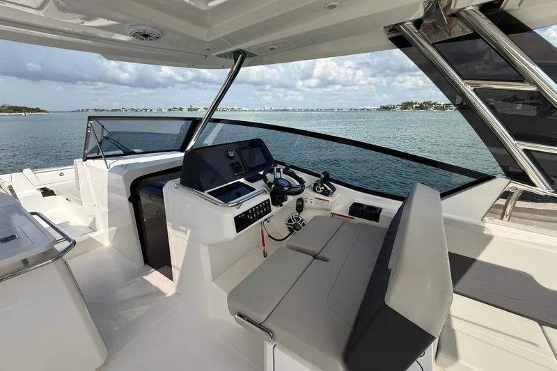 Yacht Photos Pics Aquila 32 Sport 2025 boat interior with helm, seating, and ocean view.
