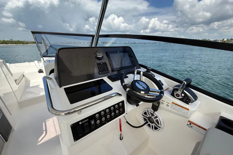  Yacht Photos Pics Helm of 2025 Aquila 32 Sport boat with modern controls and scenic ocean view.