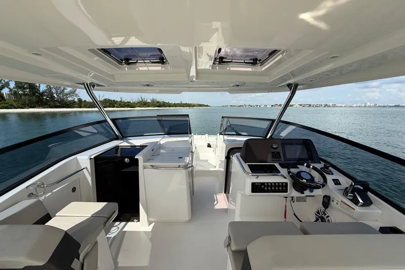  Yacht Photos Pics Interior view of 2025 Aquila 32 Sport boat, featuring modern helm and seating.