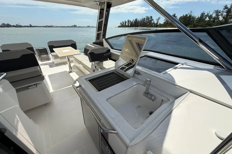  Yacht Photos Pics Aquila 32 Sport 2025 yacht interior with sink and seating area, overlooking serene waters.