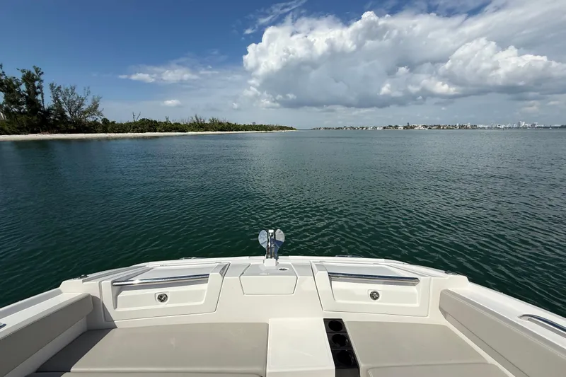  Yacht Photos Pics Aquila 32 Sport 2025 boat on calm water with scenic coastal view.