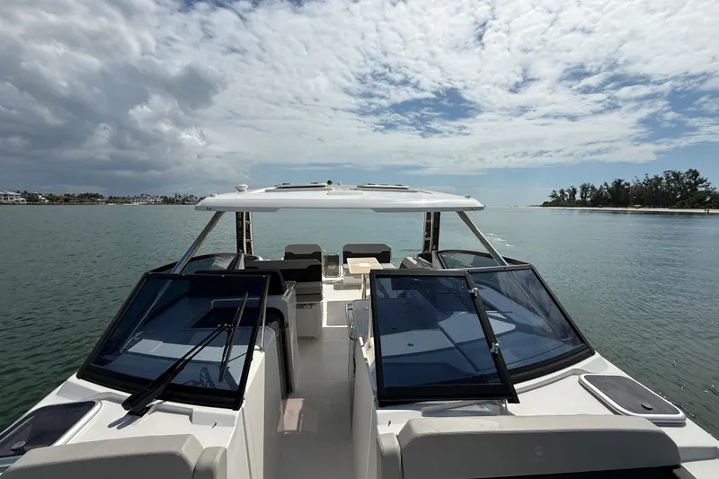 Yacht Photos Pics Aquila 32 Sport 2025 cruising on calm waters under a partly cloudy sky.