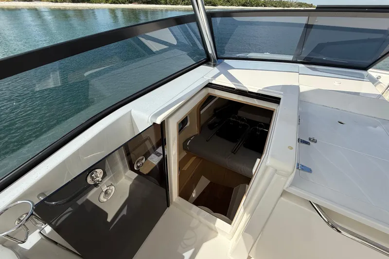  Yacht Photos Pics 2025 Aquila 32 Sport boat interior with open hatch, sleek design, and waterfront view.