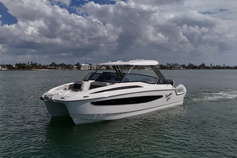  Yacht Photos Pics 2025 Aquila 32 Sport boat on calm water under cloudy sky.