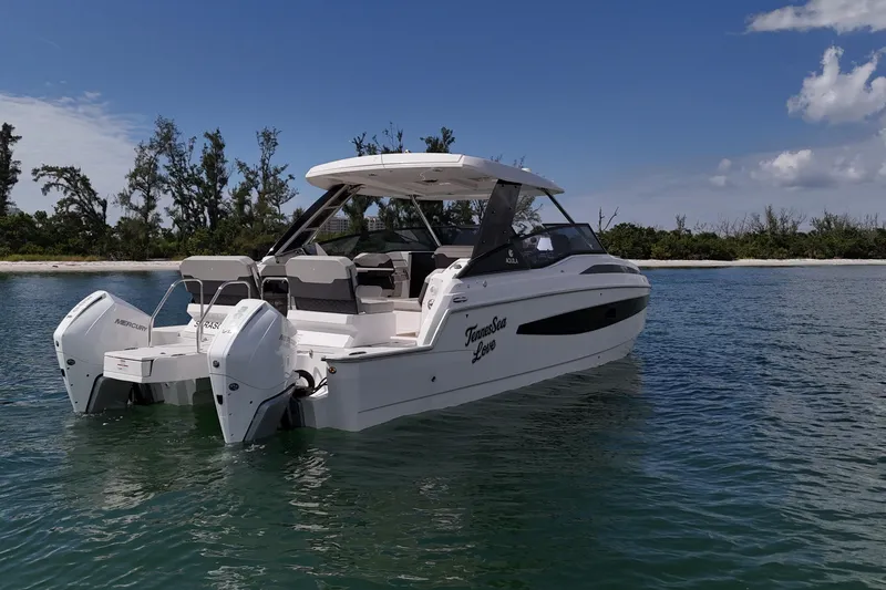  Yacht Photos Pics 2025 Aquila 32 Sport boat on calm water, featuring dual Mercury engines.